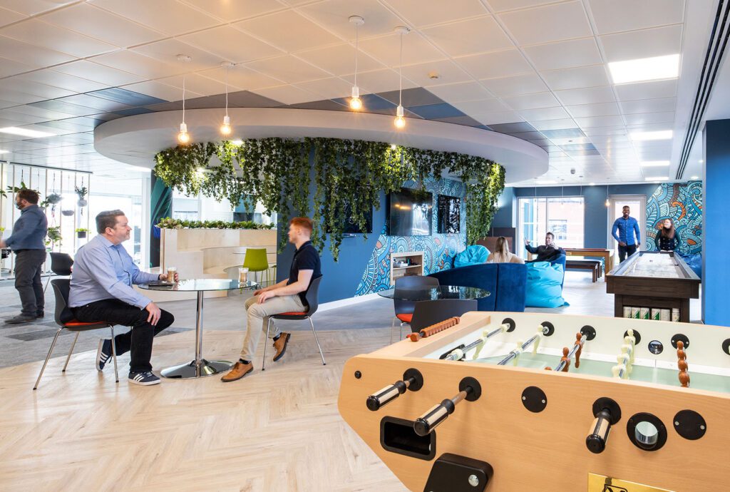 Table football, hanging foliage, and employees having a coffee together at Xledger after their fit-out by Interaction.