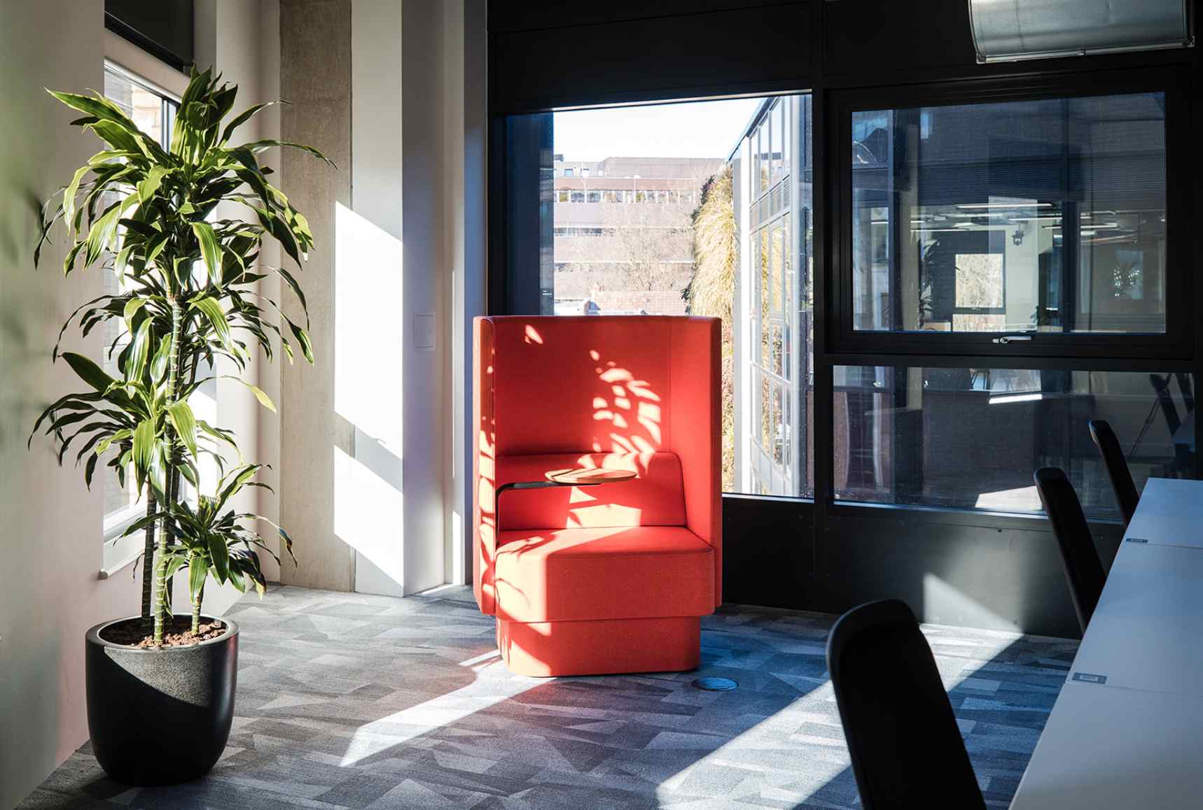 Orange booth chair for focused work with lots of natural light, office design by Interaction.