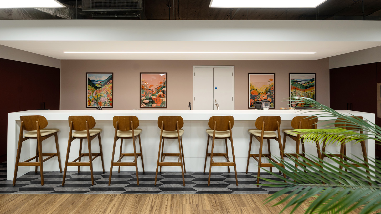 Wooden bar stools line the long workspace of the communal kitchen