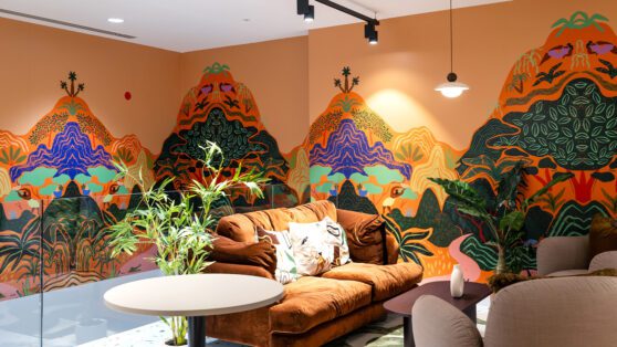 Communal area with bright orange mural on the wall