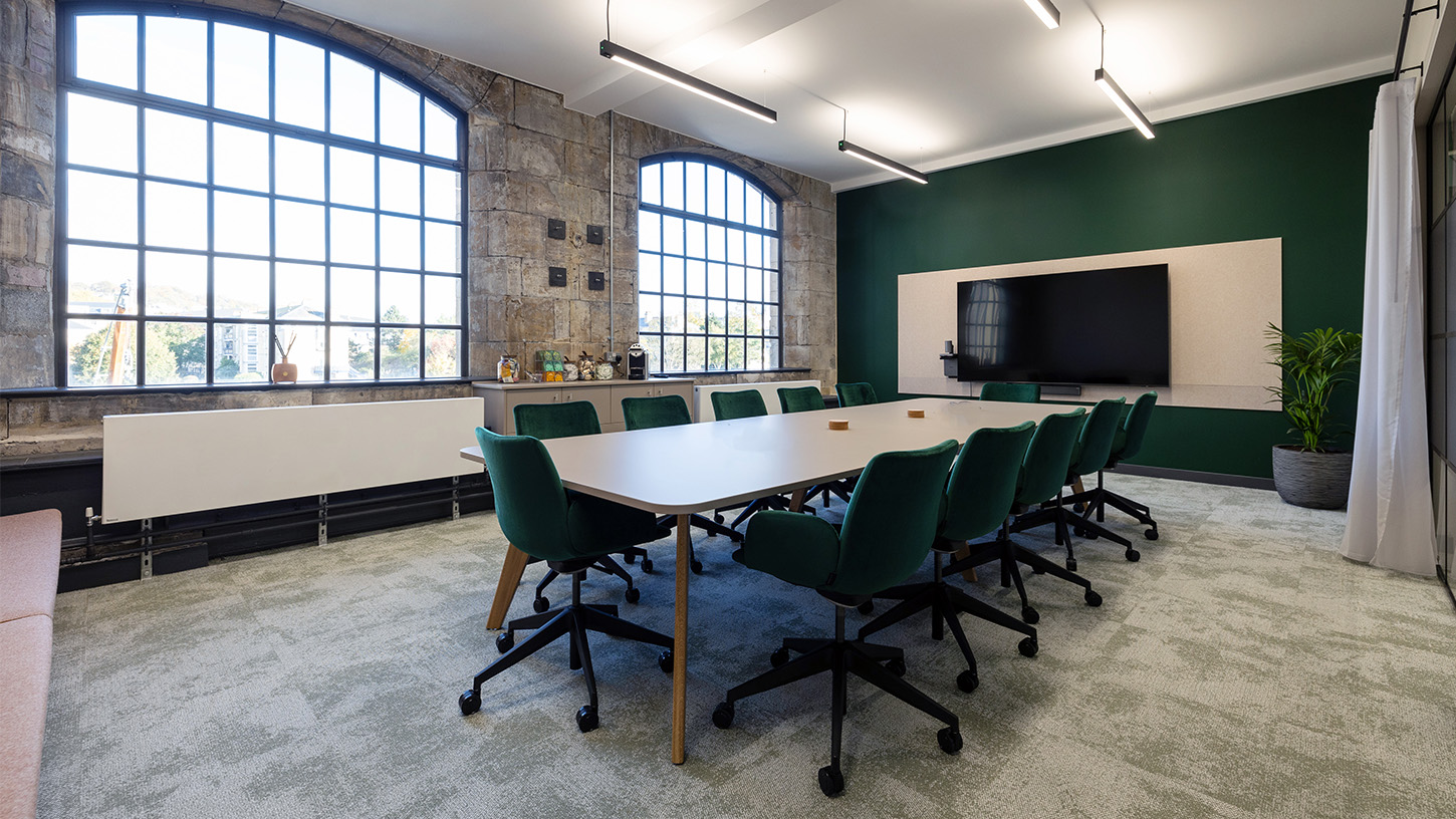 The L&C boardroom with big windows and green velvet swivel chairs