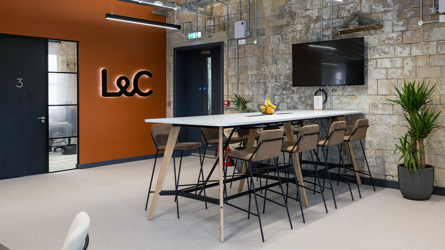 L&C entrance showing feature rust coloured wall and lit-up L&C logo