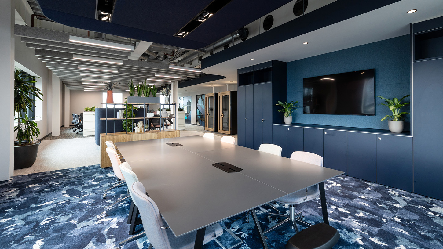 Office meeting space with blue watercolour carpet, blue cupboards and grey table