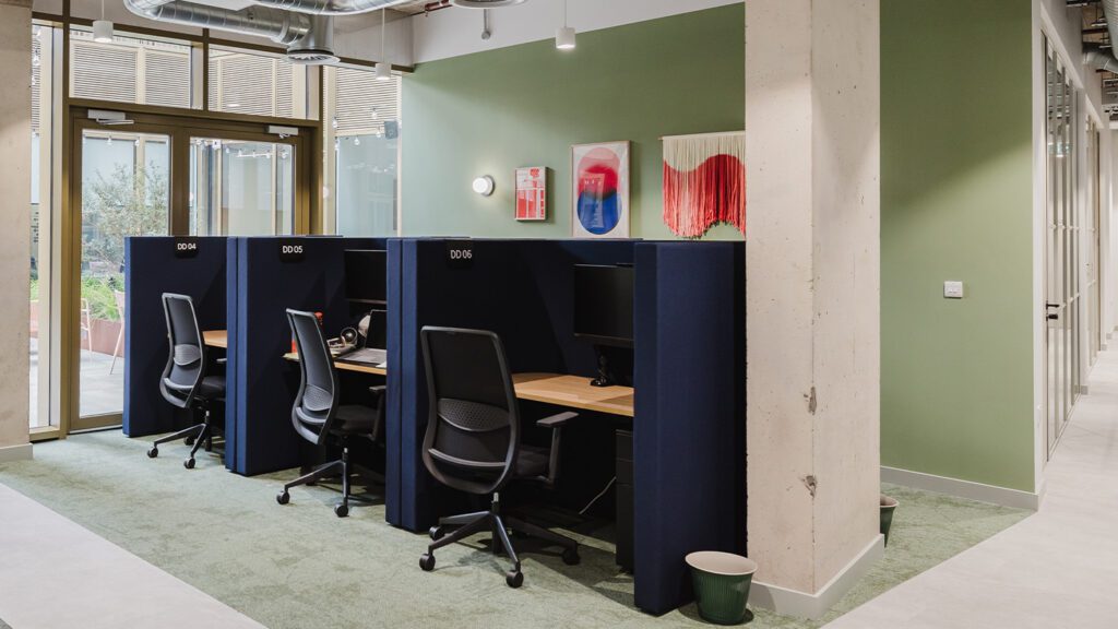 Three navy blue focus booths in a light and bright office