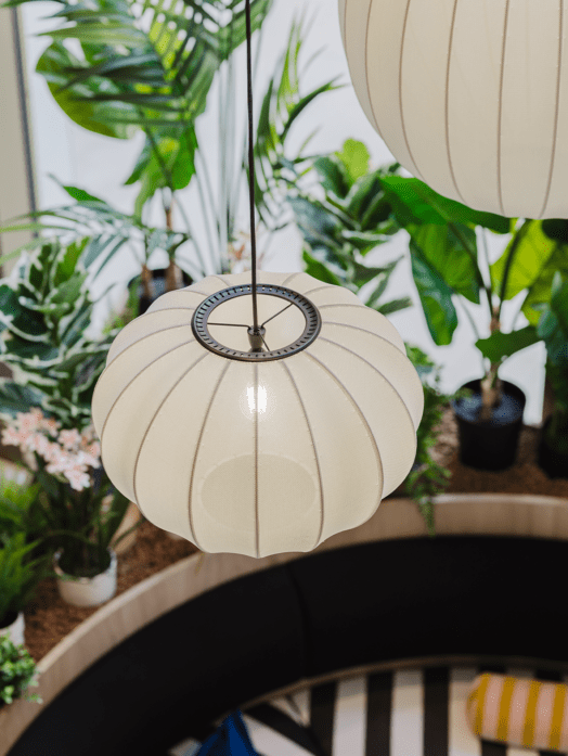 closeup of statement hanging pendant lights made out of fabric, hanging above indoor planting