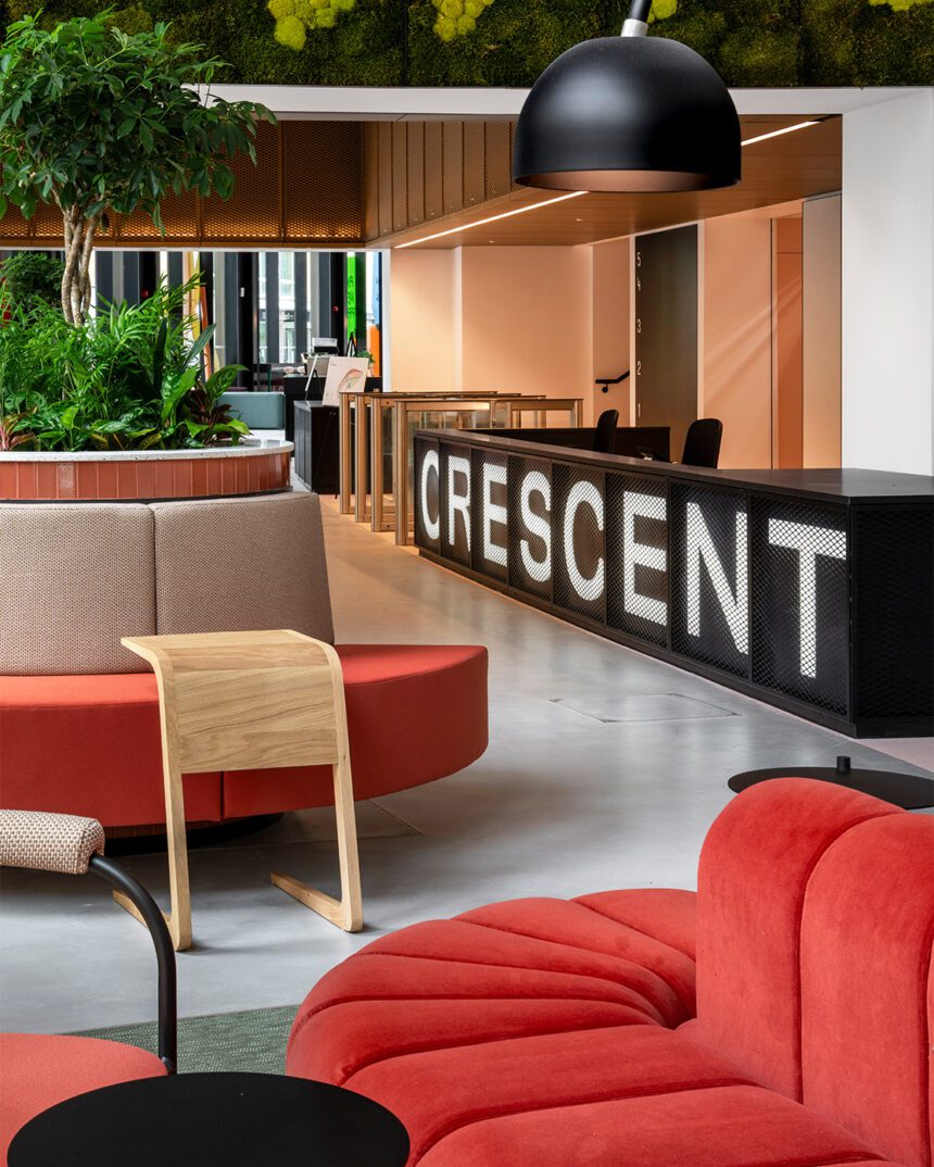 A modern reception space with large branded Crescent reception desk and red seating