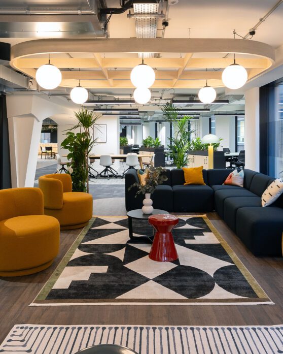 a modern office seating area with yellow armchairs and navy blue sofa