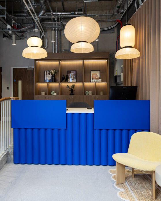 Electric blue reception desk with feature pendant lights above