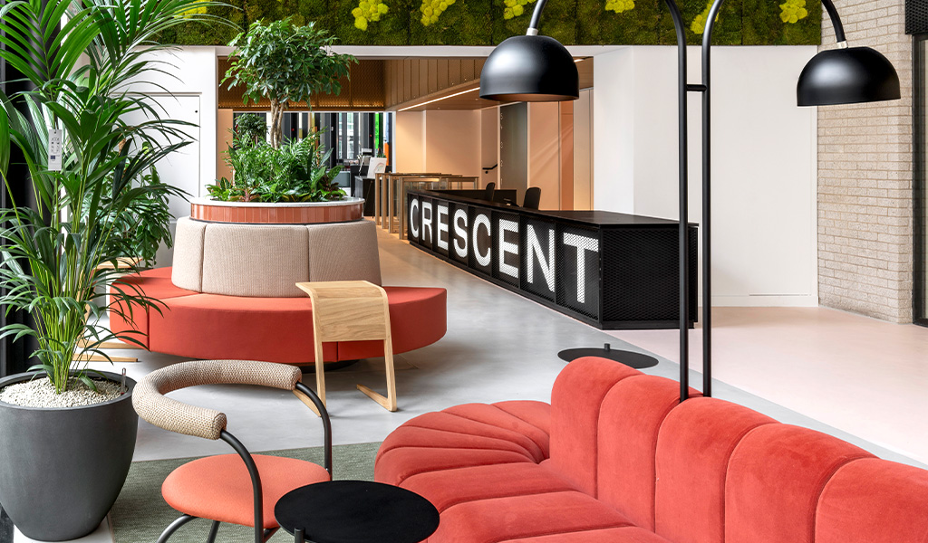 A modern reception space with large branded Crescent reception desk and red seating