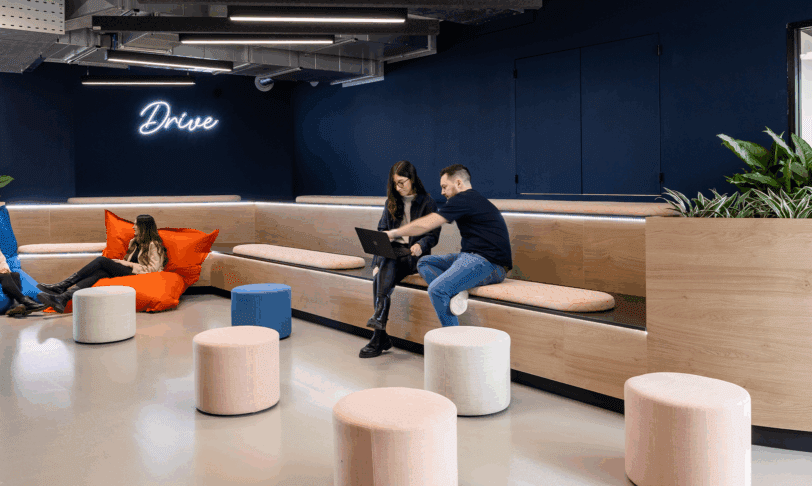 People sat on tiered seating and giant beanbags in modern office breakout space