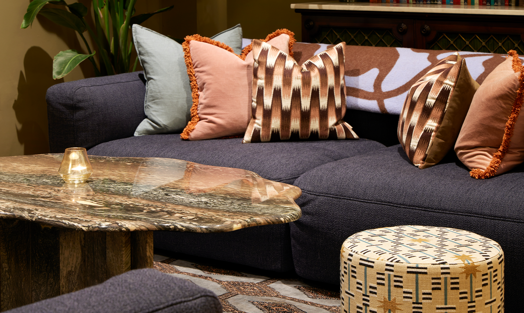 Office sofa area with colourful patterned cushions, large marble coffee table and star print footstool