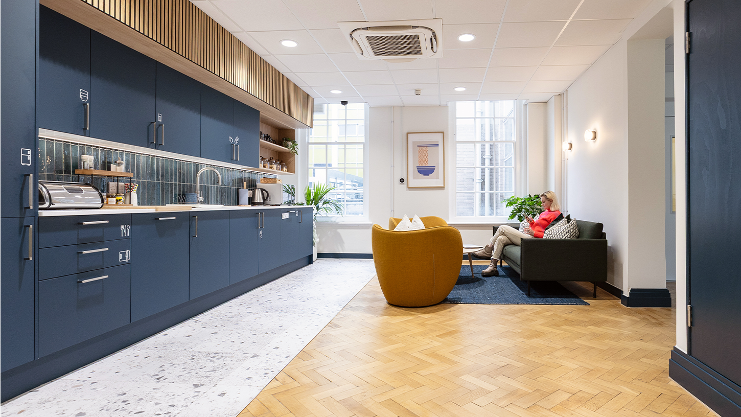 Office teapoint with navy cabinets and oak parquet flooring