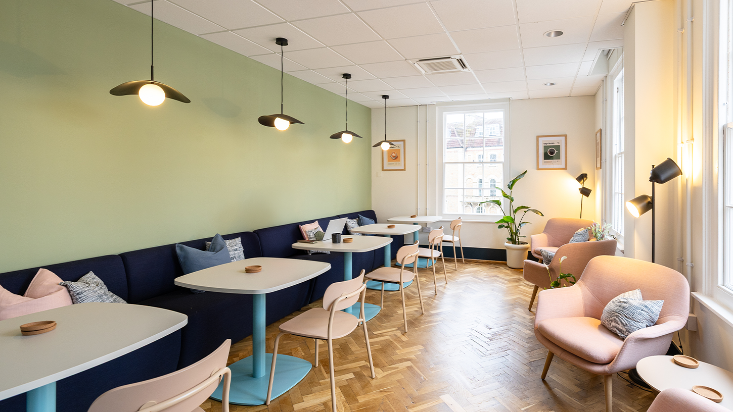 Office breakout space with soft green wall and oak parquet flooring