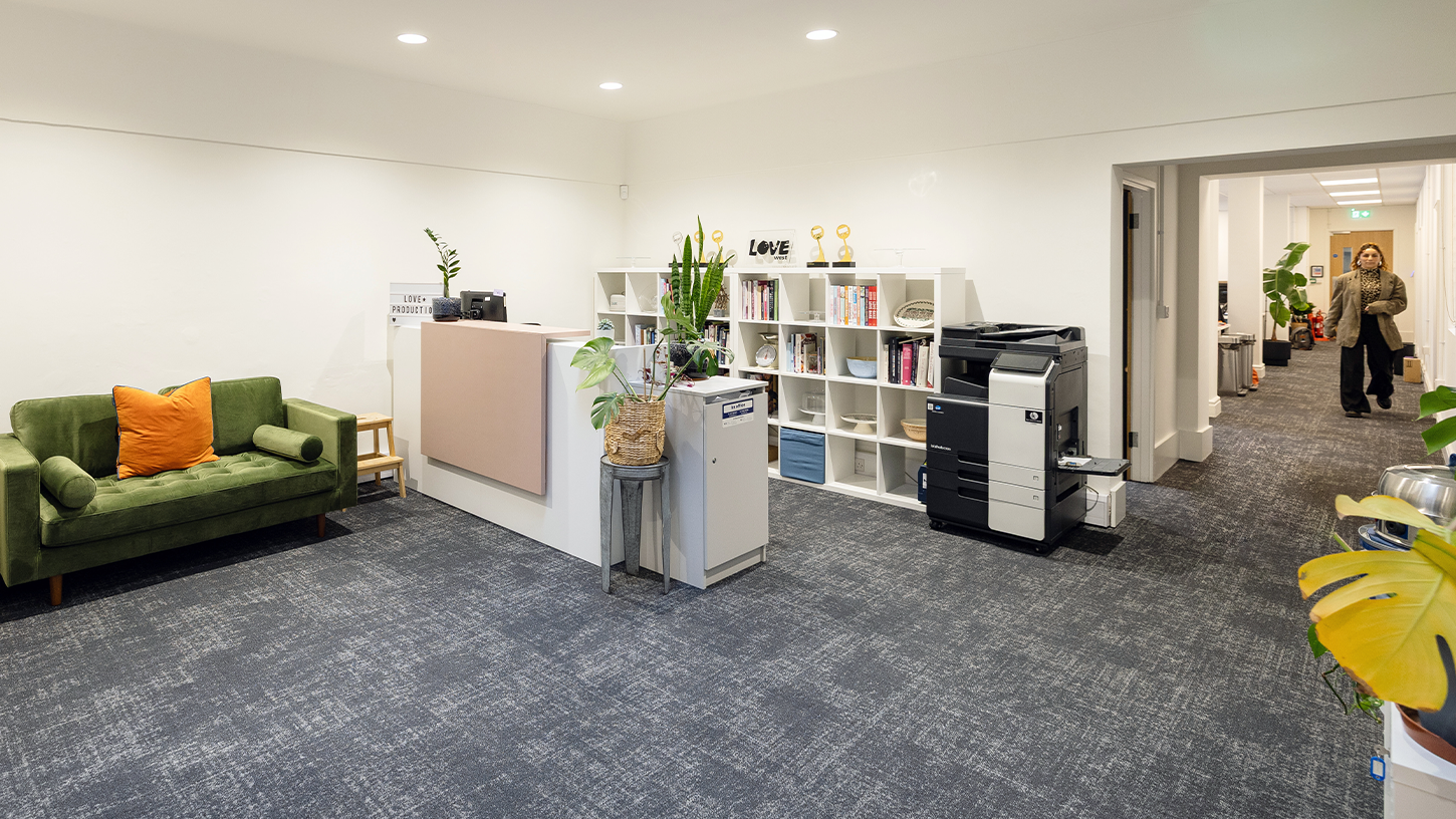 Modern office reception space with green sofa