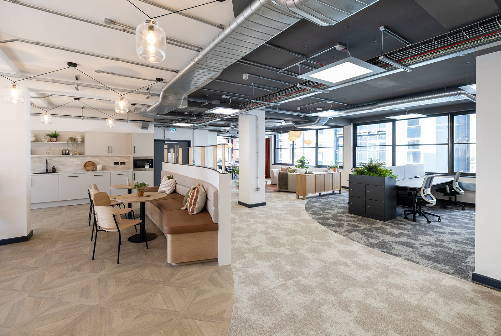 A broken-plan office with coffee bar setaing and desks