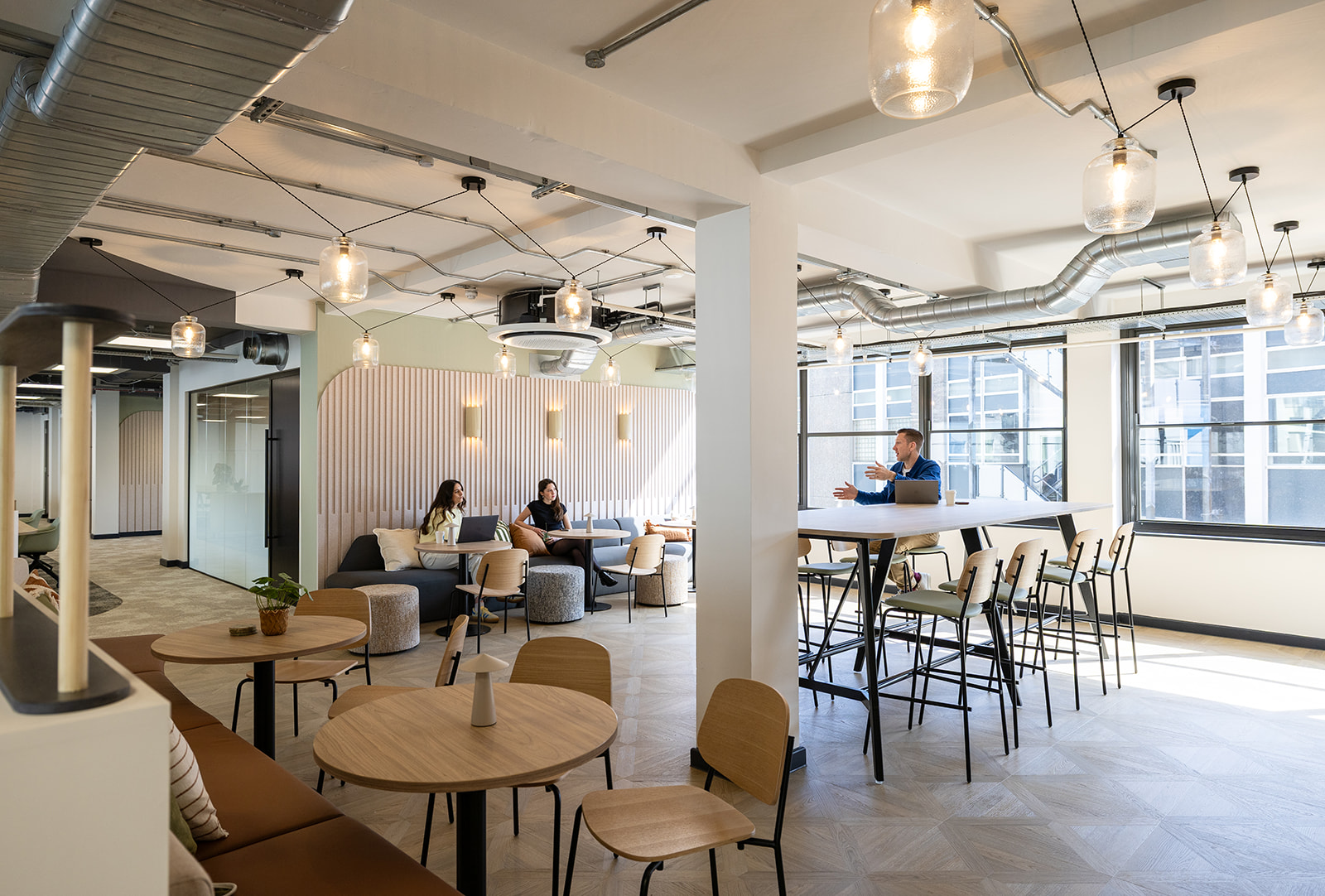 An open plan office in neutral colours with greens and oak shades