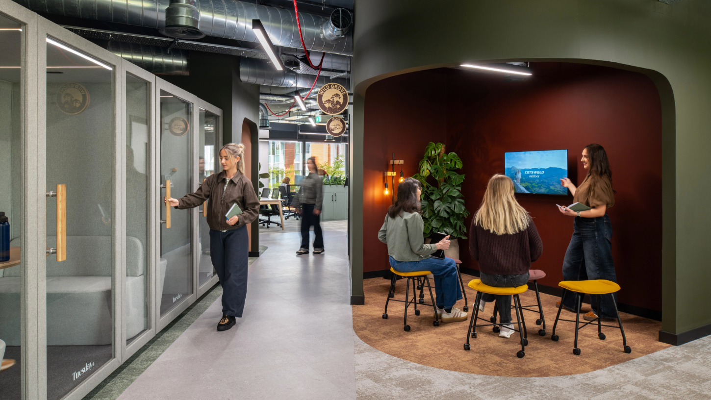 A cross section of office space with an alcove meeting area and individual phone booths, with earthy mauve and sage green tones.