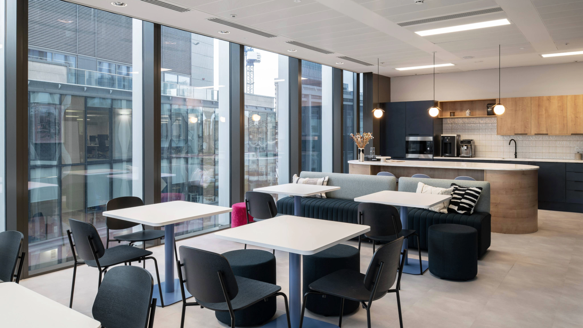An open plan kitchen space with floor to ceiling windows.